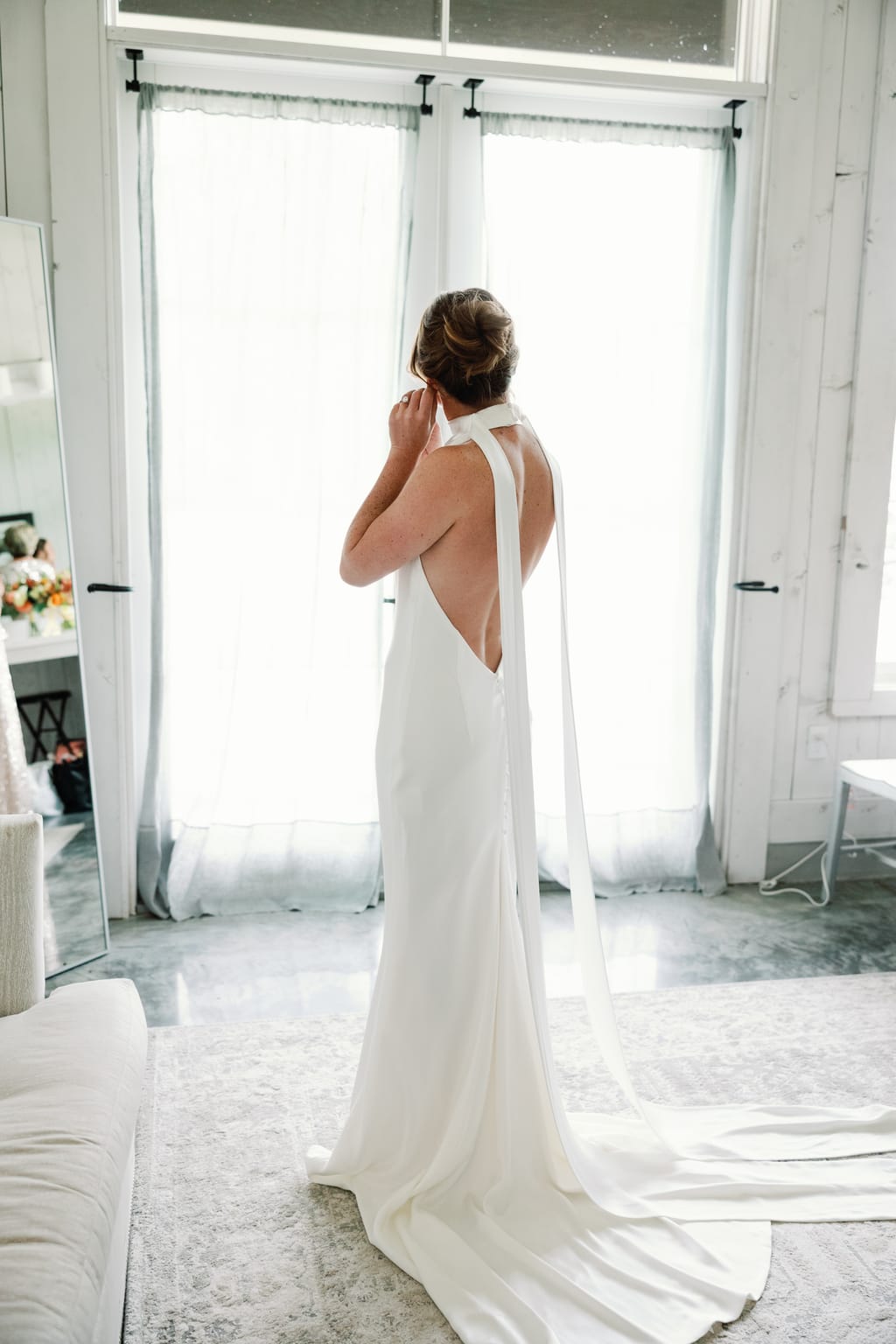 Bride in an open-back gown by the window before the ceremony, a 4U Ranch wedding in Park City, Utah