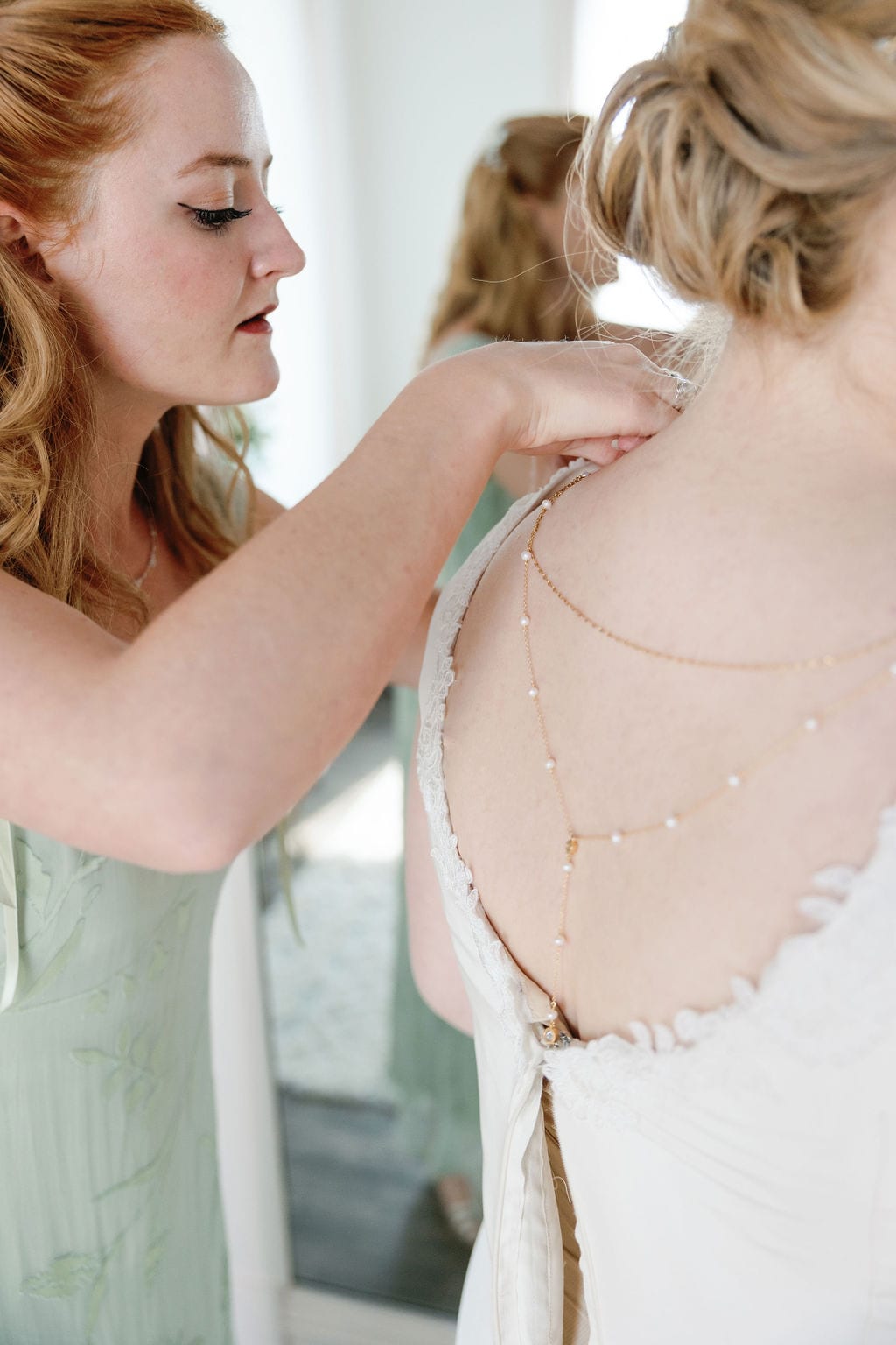 Grace and Miles wedding at Eldredge Manor, the bride steps into her gown