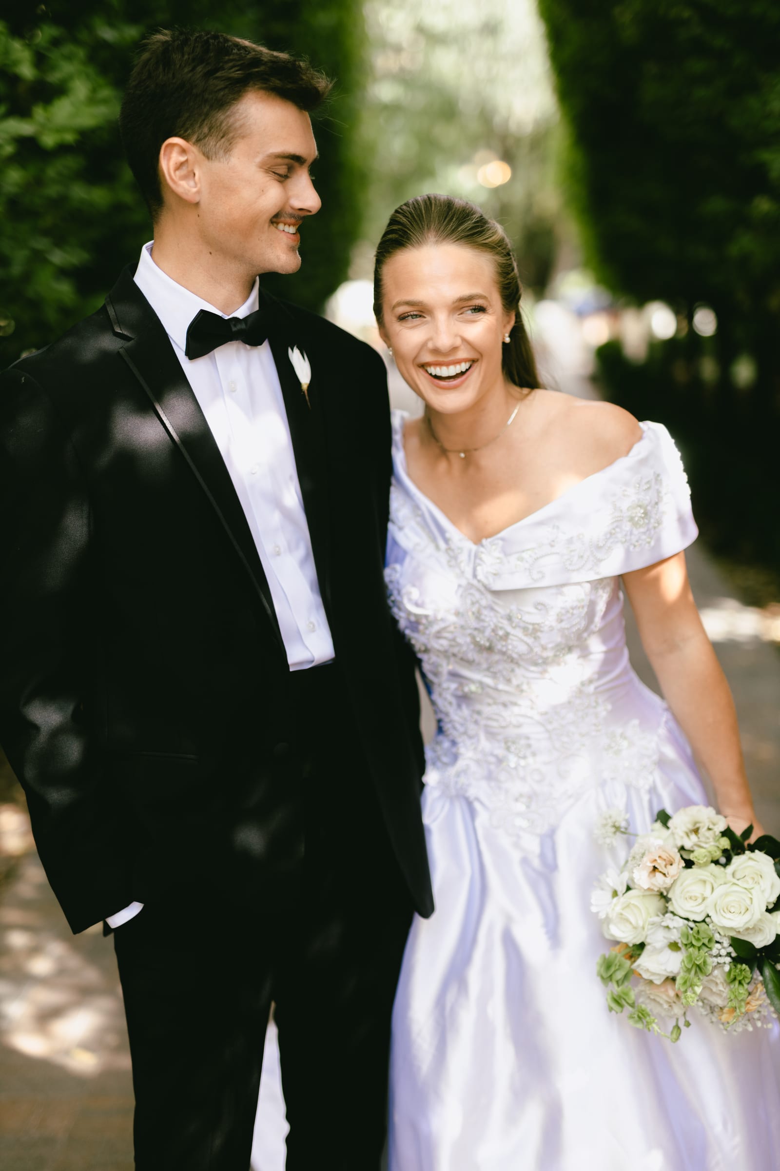 Kyle and Marita laughing together in the gardens, a Bellissimo Gardens wedding in Utah