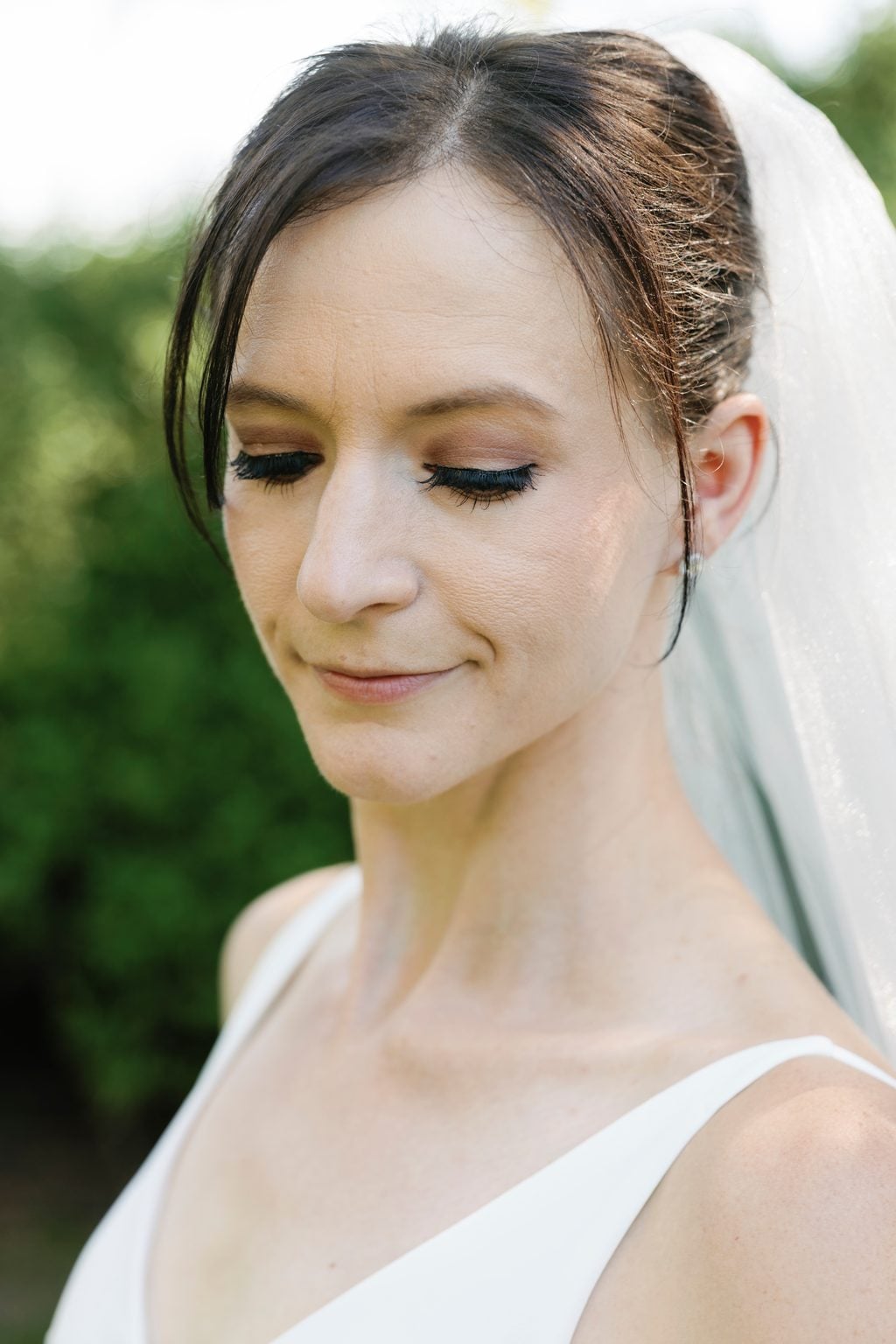 A soft portrait of the bride Mallory in her veil before the ceremony