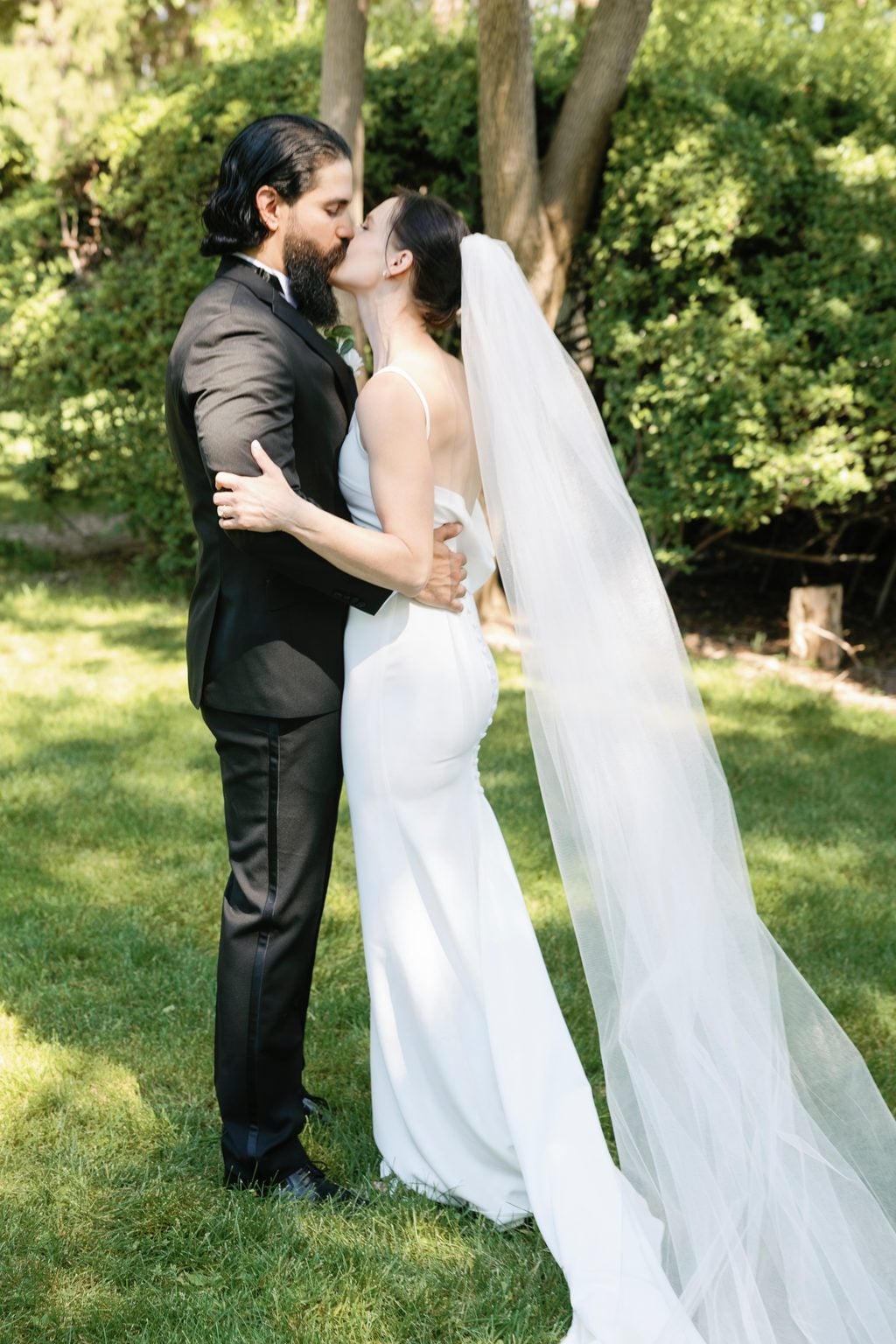 The couple kissing among the hedges at their private garden wedding in Utah