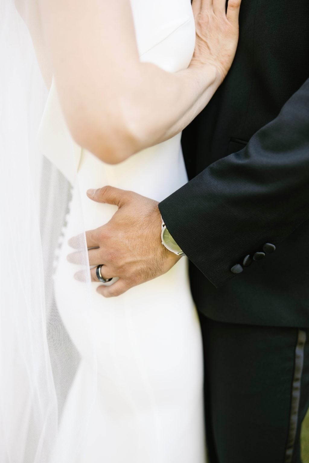 The couple's hands intertwined with the bouquet and wedding rings, a Utah wedding