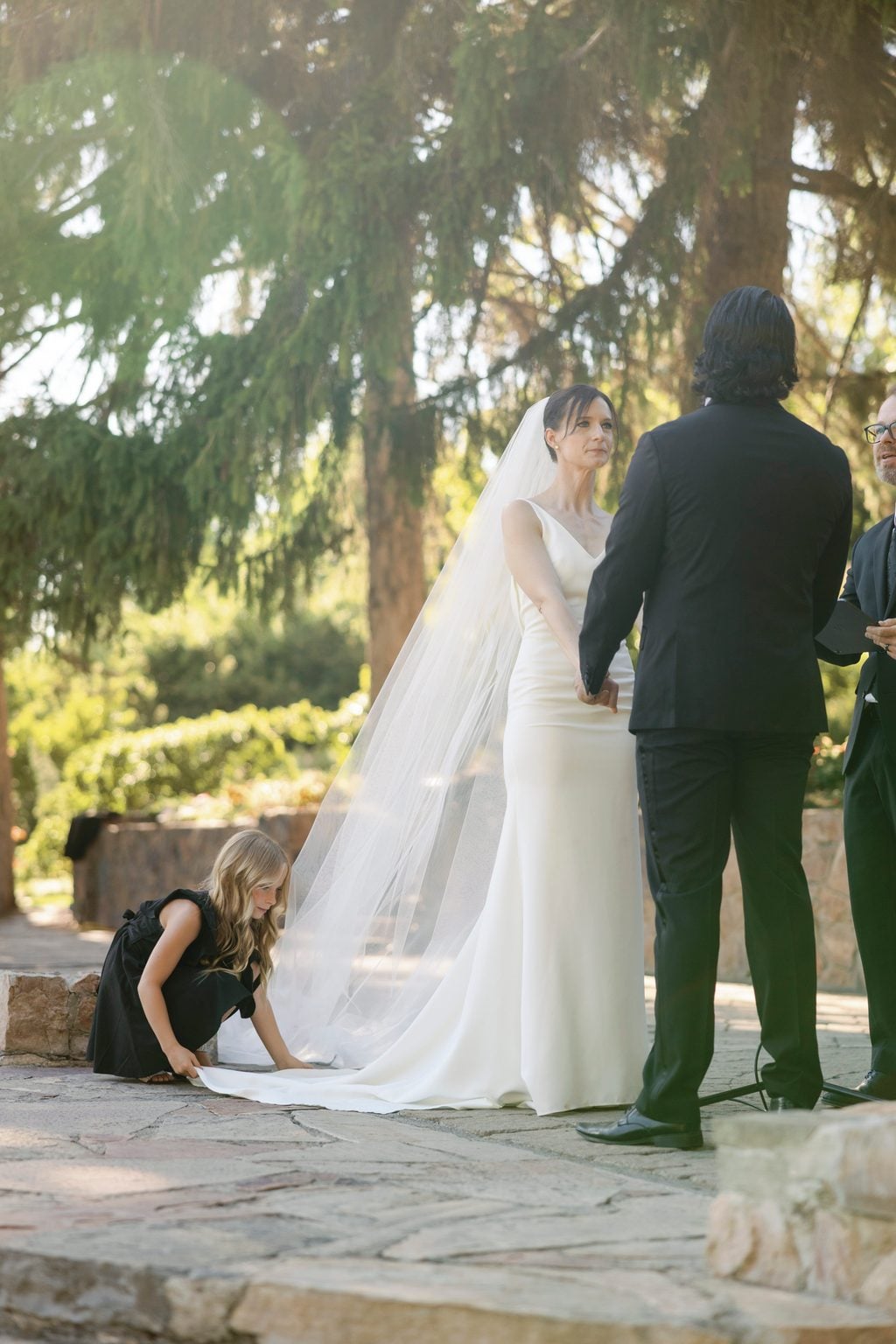 The first kiss at the altar beneath the veil and string lights, a Utah garden ceremony