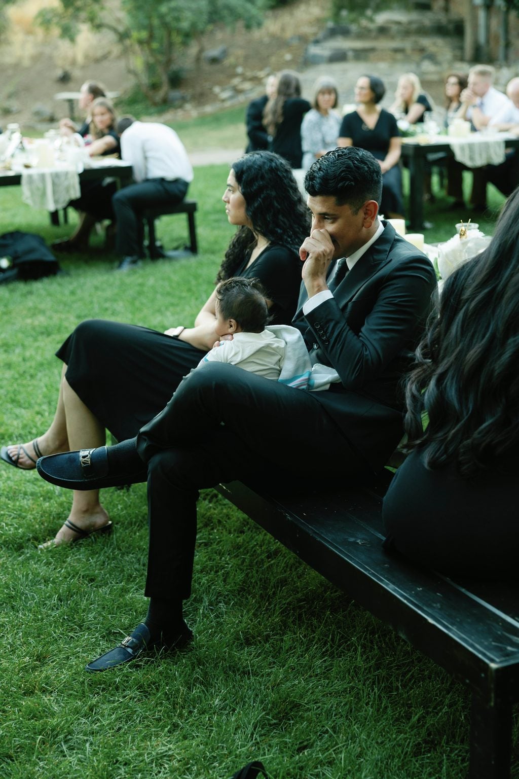 The newlyweds resting together at dusk as the string lights begin to glow