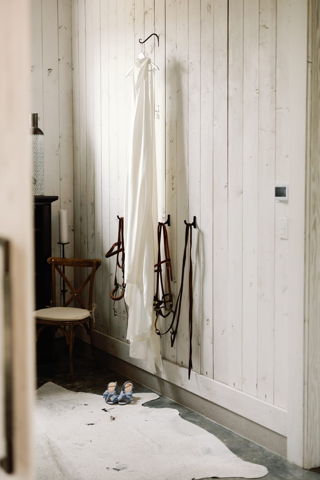 The bride's gown hanging on a rustic barn door at 4U Ranch, a Park City, Utah wedding venue