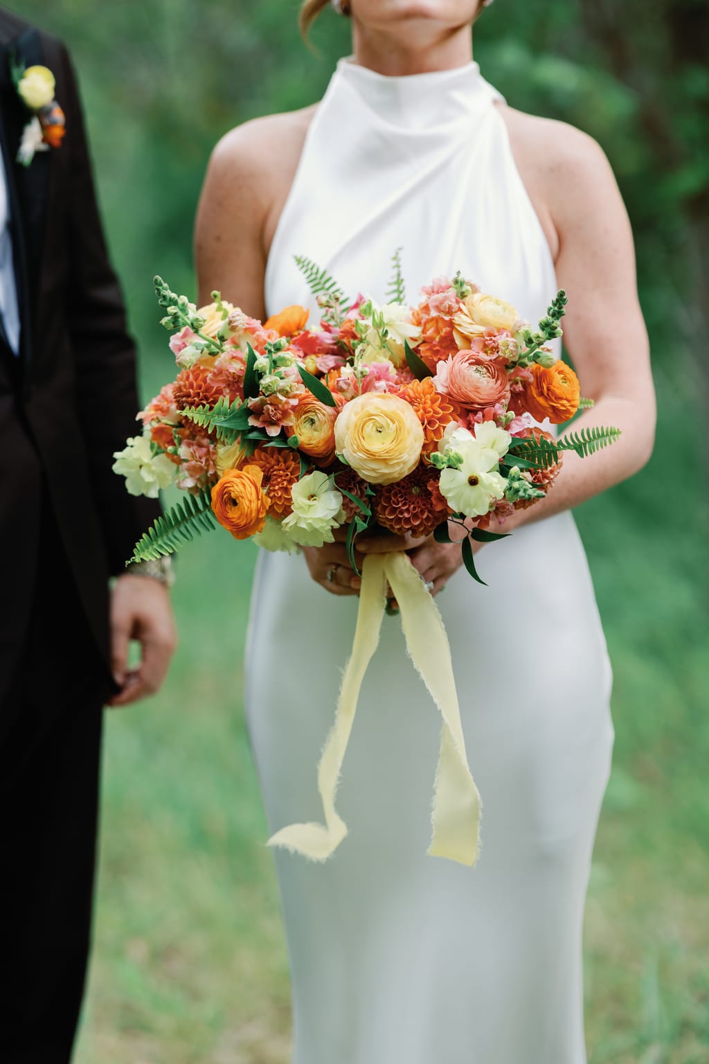 Bride holding a marigold and peach bouquet in a halter gown, 4U Ranch wedding, Park City Utah