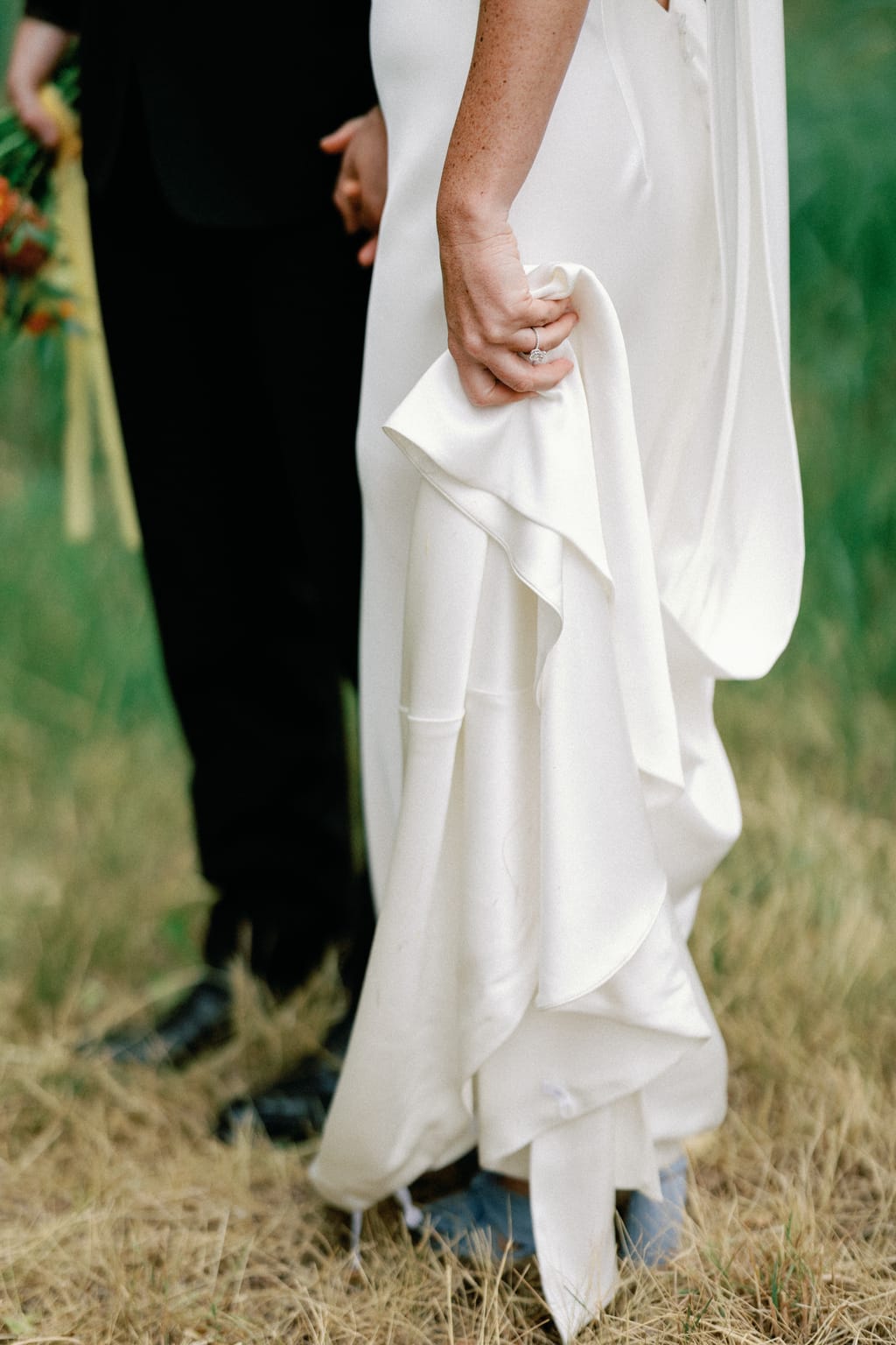The couple holding hands, gown and bouquet detail at a 4U Ranch wedding in Park City, Utah