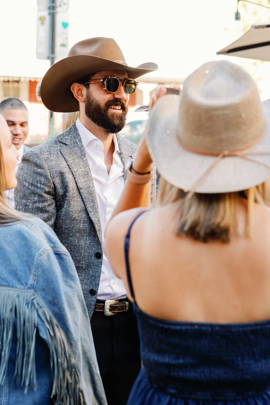 The groom in a cowboy hat at cocktail hour, an outdoor 4U Ranch wedding in Park City, Utah