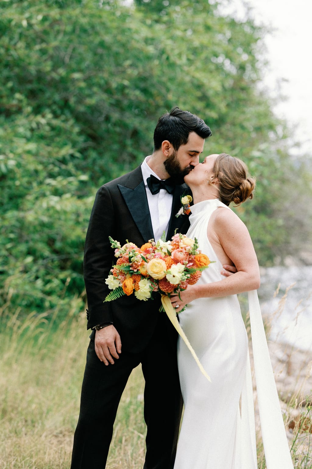 Bride and groom share a kiss with her autumn bouquet, 4U Ranch wedding, Park City Utah