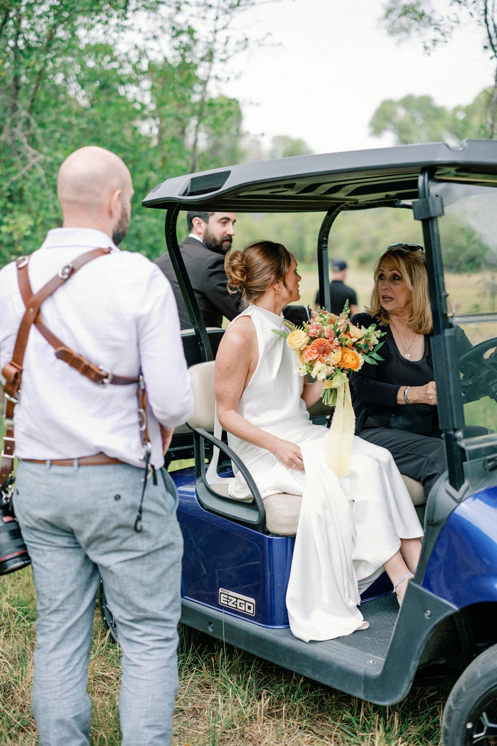 The couple ride off in a golf cart, a candid moment at a 4U Ranch wedding in Park City, Utah