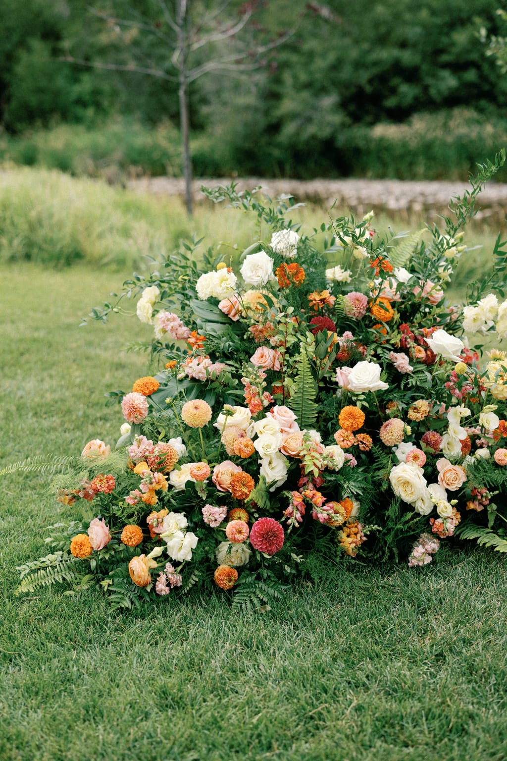 Lush orange and peach ceremony florals at a 4U Ranch wedding in Park City, Utah