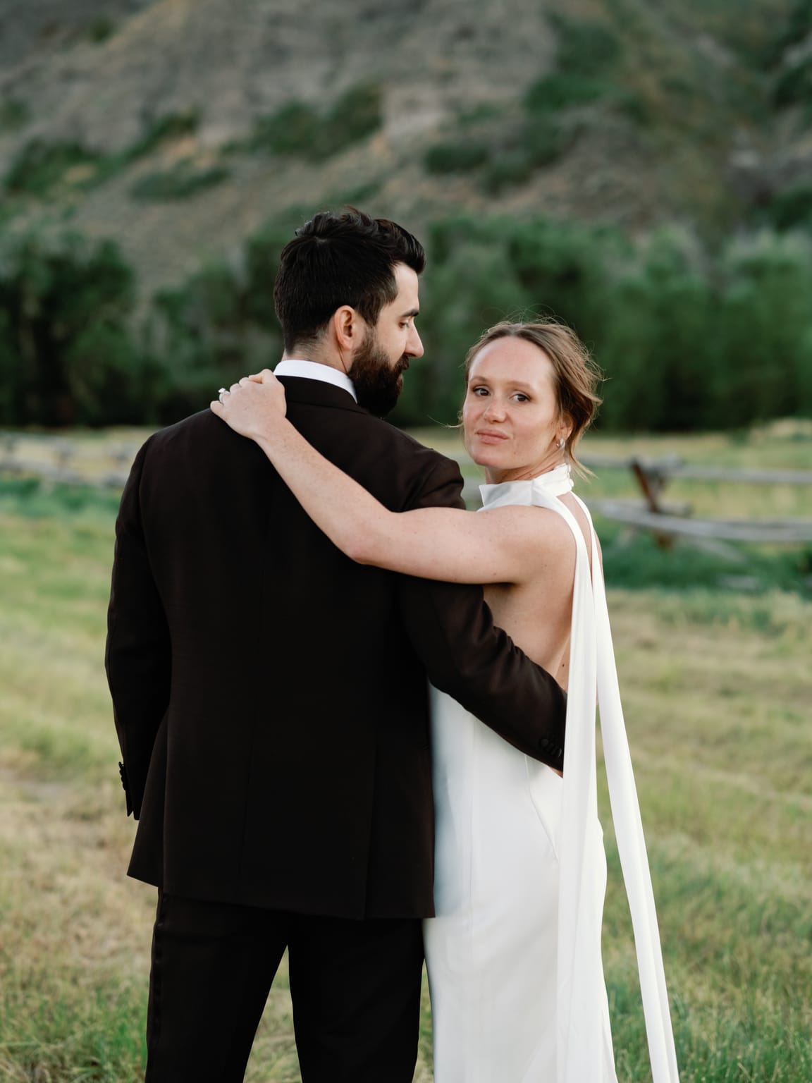 The couple in a tender embrace in the golden meadow, a 4U Ranch wedding in Park City, Utah