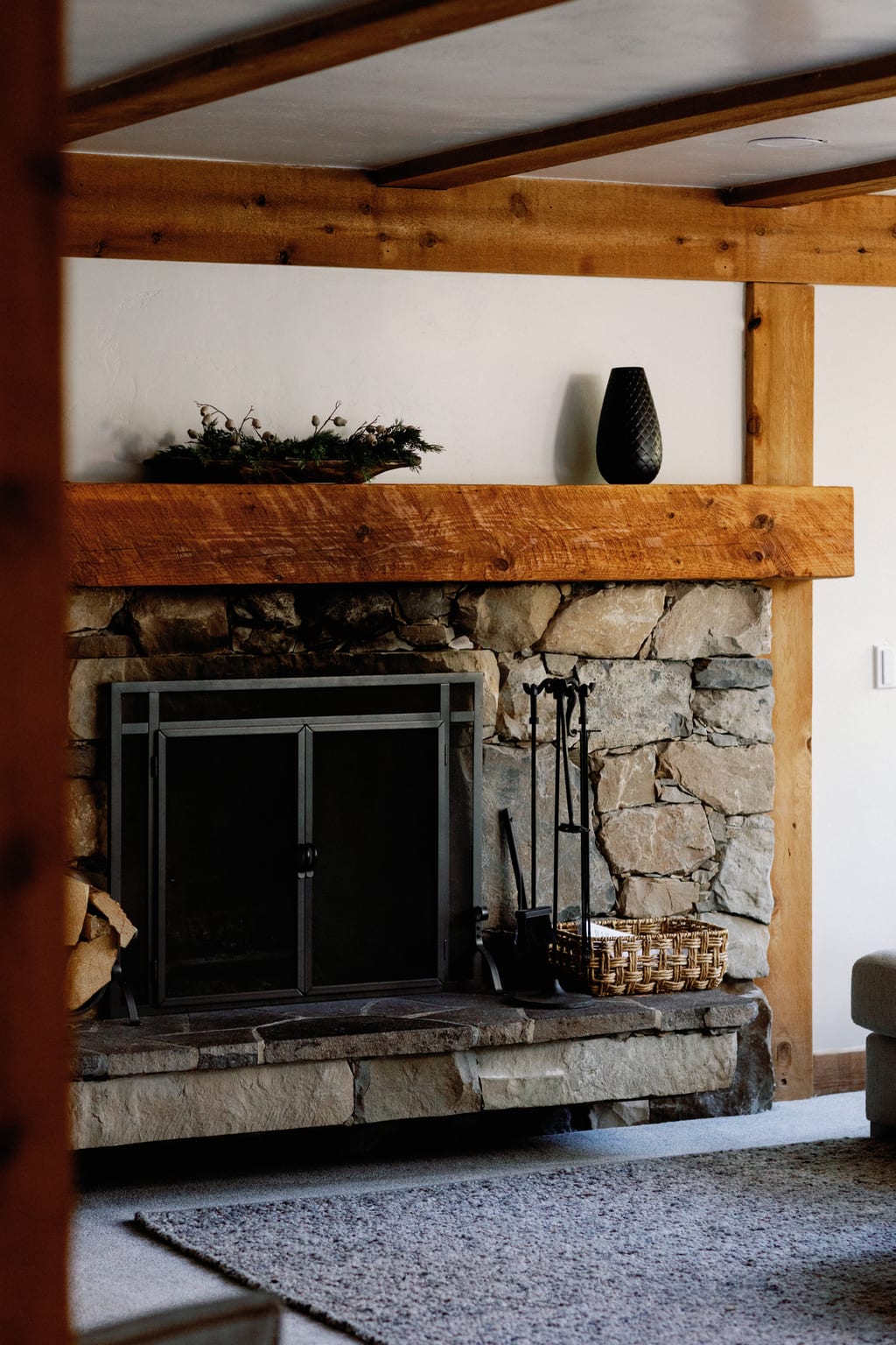 The lodge interior with a stone fireplace and timber beams, a private Sundance residence