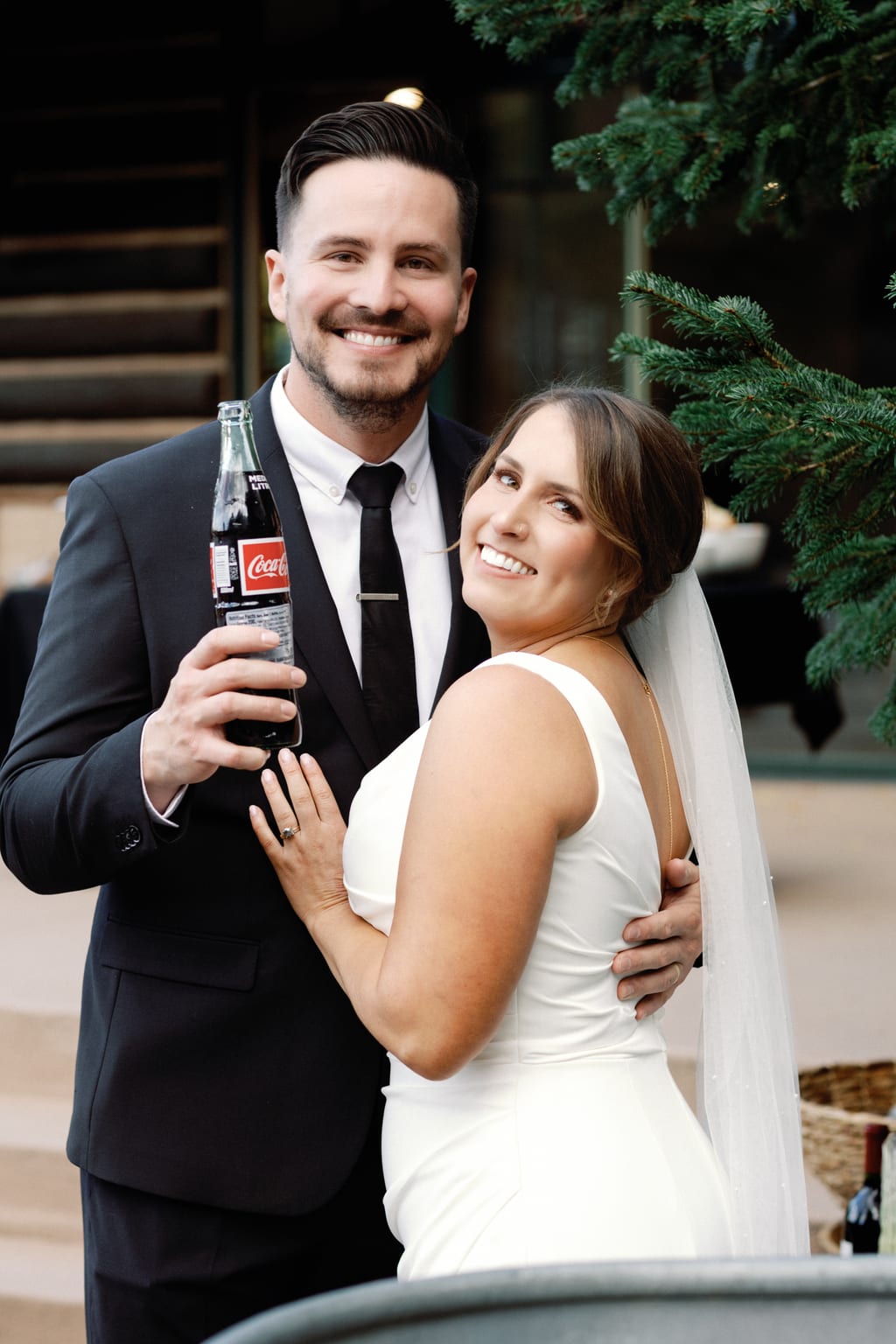 The couple embracing under string lights at the reception, Sundance mountain wedding