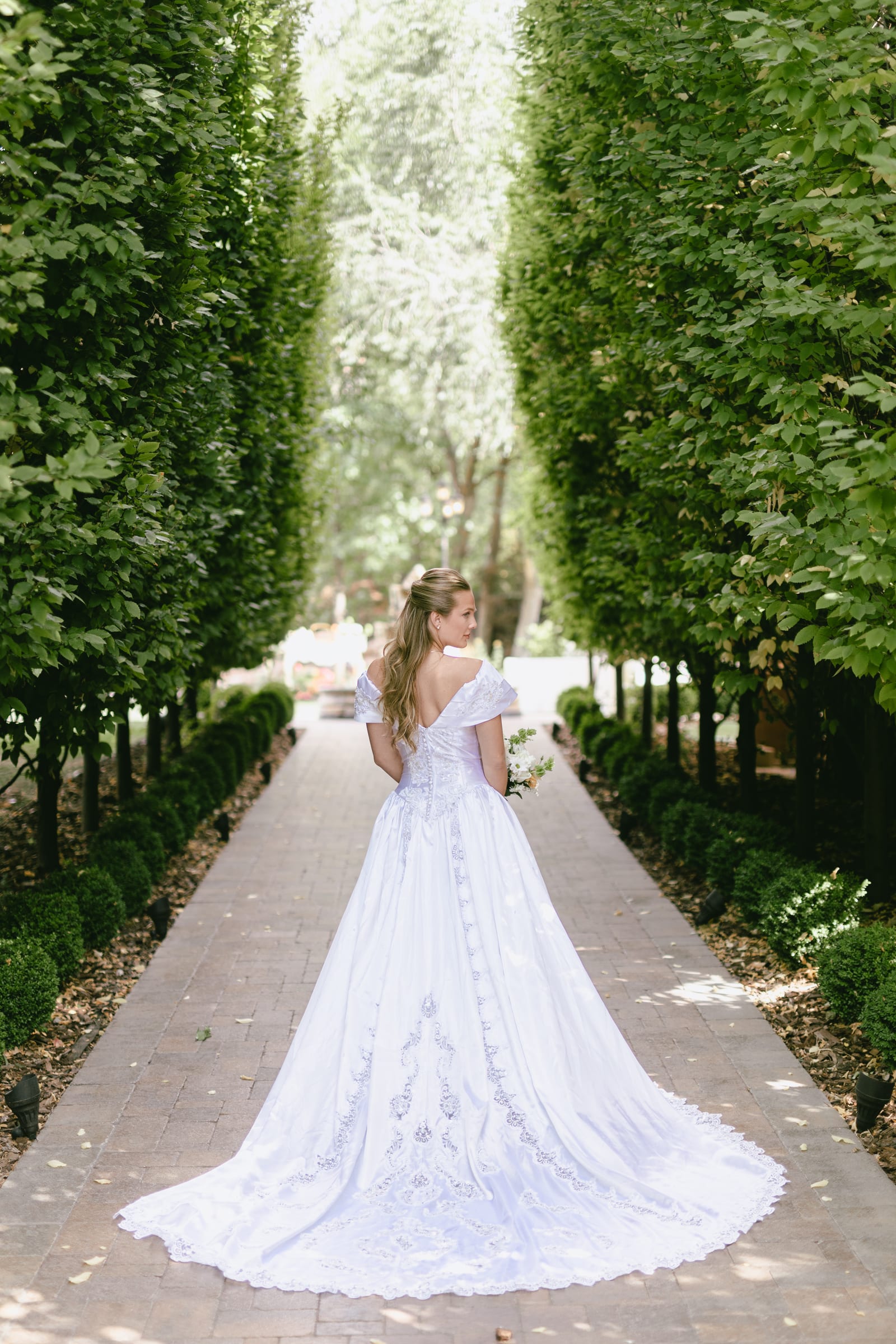 Wedding gown in the garden alley at Bellissimo Gardens